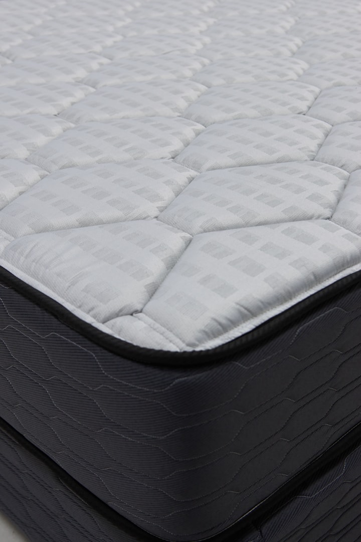 a man is working on a mattress in a warehouse